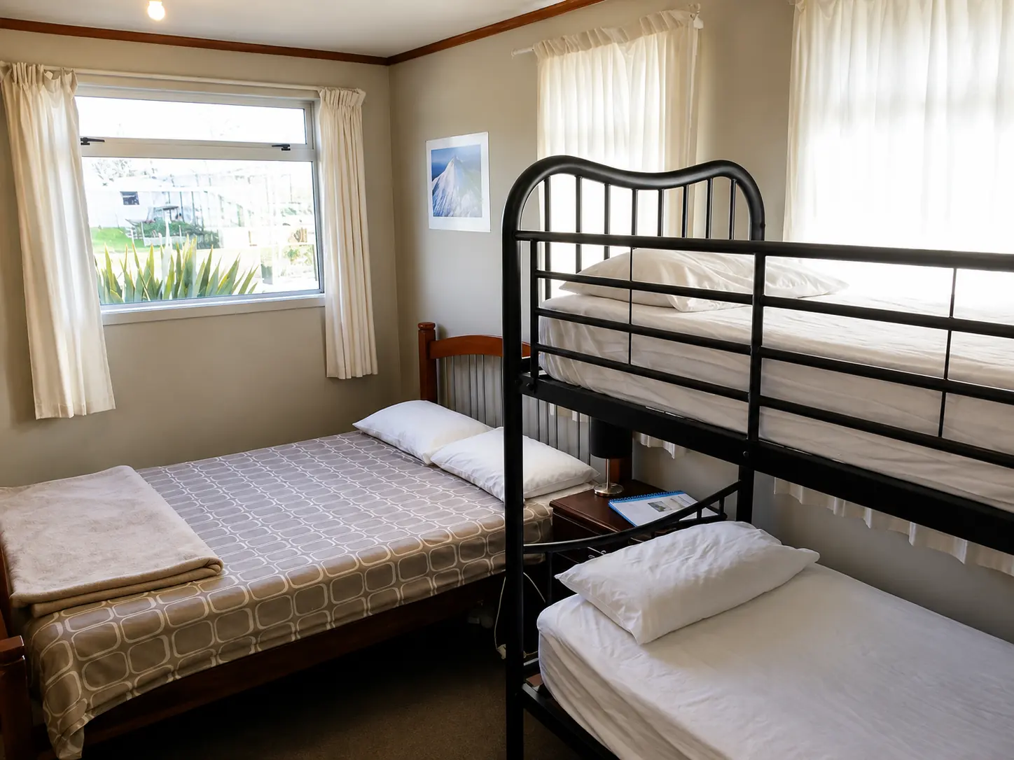 Shared dormitory room with a double bed, bunk beds and a garden window