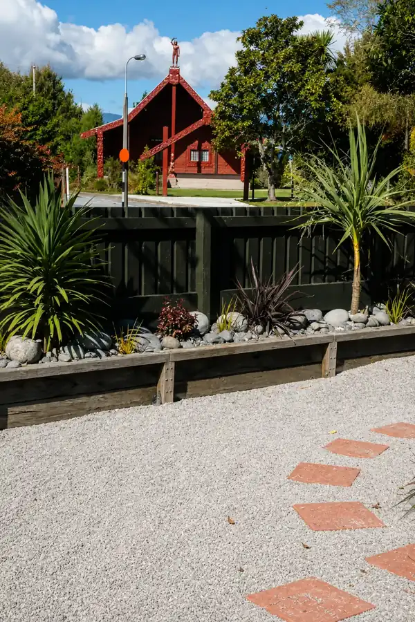 Planted garden bed with river stones beside the lodge driveway