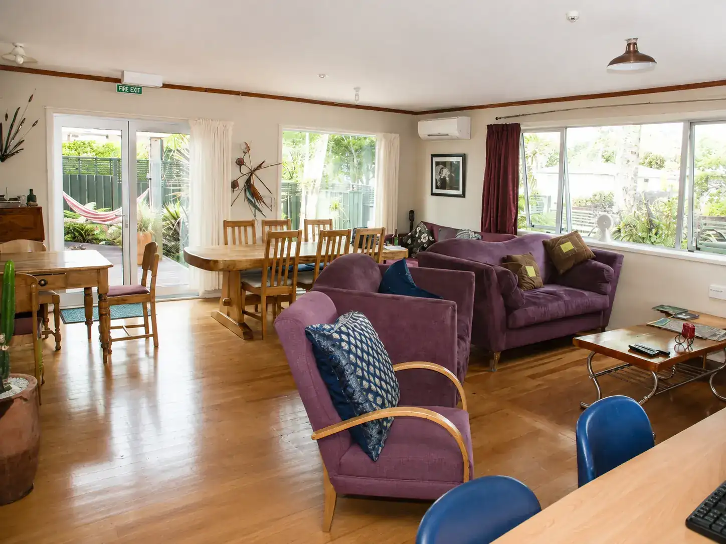 Communal dining area with a long timber table and comfortable seating